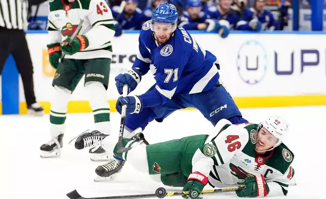 Minnesota Wild defenseman Jared Spurgeon (46) falls down as he chases the puck against Tampa Bay Lightning center Anthony Cirelli (71) during the second period of an NHL hockey game Tuesday, March 24, 2026, in Tampa, Fla. (AP Photo/Chris O'Meara)
