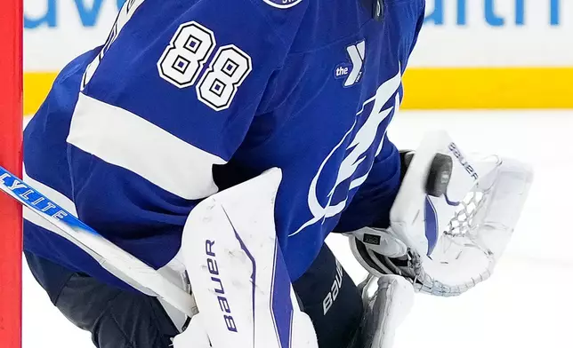 Tampa Bay Lightning goaltender Andrei Vasilevskiy (88) makes a glove save on a shot by the Minnesota Wild during the third period of an NHL hockey game Tuesday, March 24, 2026, in Tampa, Fla. (AP Photo/Chris O'Meara)