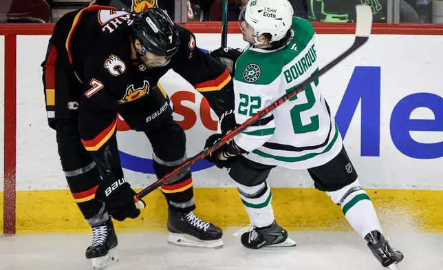 Dallas Stars' Mavrik Bourque, right, is checked by Calgary Flames' Kevin Bahl during the second period of an NHL hockey game in Calgary, Alberta on Tuesday, March 3, 2026. (Jeff McIntosh/The Canadian Press via AP)