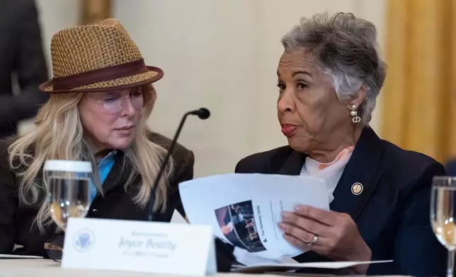 Mindy Levine, left, listens as Rep. Joyce Beatty, D-Ohio, talks before President Donald Trump arrives for a board meeting of the John F. Kennedy Memorial Center For The Performing Arts in the East Room of the White House, Monday, March 16, 2026, in Washington. (AP Photo/Alex Brandon)