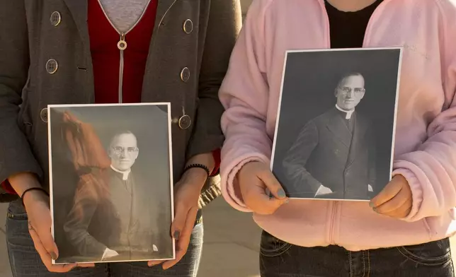 FILE - Boys Town students hold portraits of Boys Town founder Father Edward Flanagan outside St. Cecilia Cathedral in Omaha, Neb., Feb. 27, 2012. (AP Photo/Nati Harnik, File)