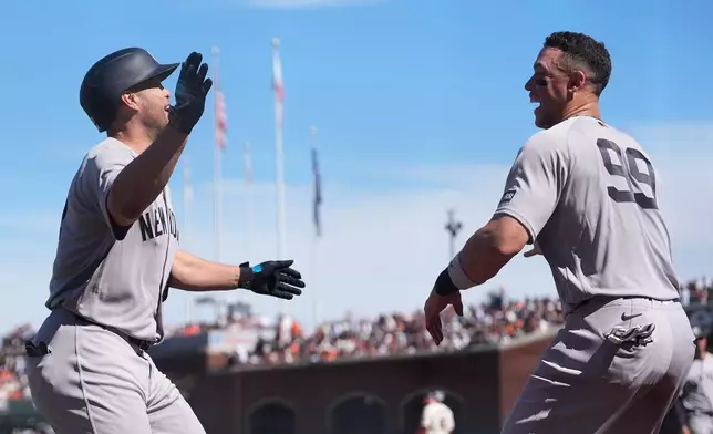 New York Yankees' Giancarlo Stanton, left, is congratulated by Aaron Judge after hitting a home run during the sixth inning of a baseball game against the San Francisco Giants in San Francisco, Friday, March 27, 2026. (AP Photo/Jeff Chiu)