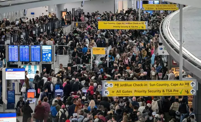 People wait in a TSA line at the John F. Kennedy International Airport, Sunday, March 22, 2026, in New York. (AP Photo/Yuki Iwamura)