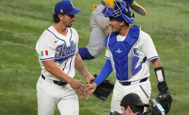 Italy pitcher Michael Lorenzen and catcher JJ D'Orazio shake hands during the fifth inning of a World Baseball Classic semifinal game against Venezuela, Monday, March 16, 2026, in Miami. (AP Photo/Lynne Sladky)