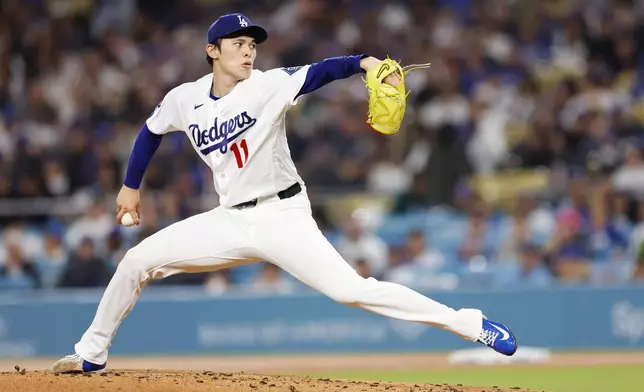 Los Angeles Dodgers starting pitcher Roki Sasaki (11) releases a pitch during the second inning of a baseball game against the Cleveland Guardians, Monday, March 30, 2026, in Los Angeles. (AP Photo/Caroline Brehman)
