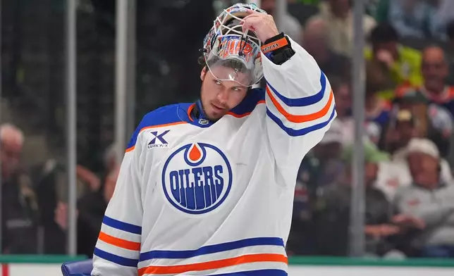 Edmonton Oilers goaltender Tristan Jarry lifts his helmet during the first period of an NHL hockey game against the Dallas Stars, Thursday, March 12, 2026, in Dallas. (AP Photo/LM Otero)