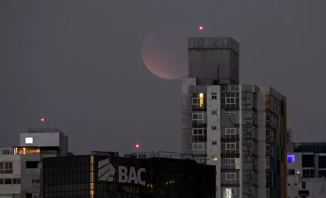 A total lunar eclipse is seen from Panama City before sunrise, Tuesday, March 3, 2026. (AP Photo/Matias Delacroix)