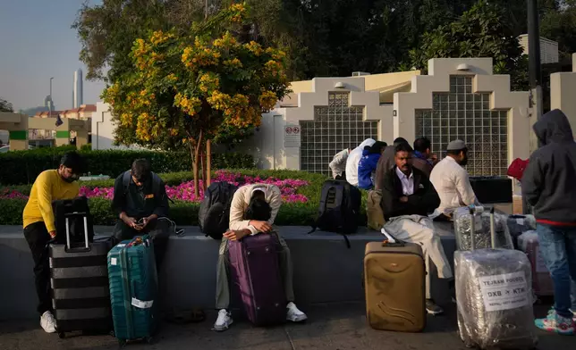 Passengers stranded by the closure of Dubai International Airport await for assistance in the airport parking lot in Dubai, United Arab Emirates, Sunday, March 1, 2026. (AP Photo/Altaf Qadri)