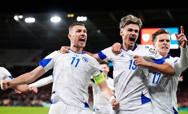 Bosnia and Herzegovina's Edin Dzeko, left, celebrates with team-mates after scoring their side's first goal during the World Cup playoff semifinal soccer match between Wales and Bosnia and Herzegovina in Cardiff, Wales, Thursday, March 26, 2026. (Nick Potts/PA via AP)