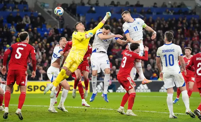 Bosnia and Herzegovina's Edin Dzeko, top right, scores their side's first goal during the World Cup playoff semifinal soccer match between Wales and Bosnia and Herzegovina in Cardiff, Wales, Thursday, March 26, 2026. (Nick Potts/PA via AP)