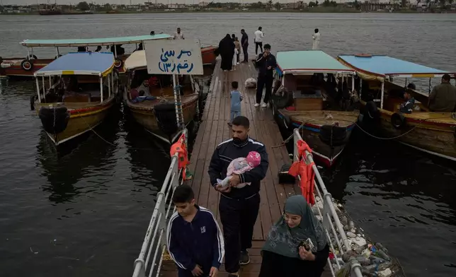 A family arrives from a boat trip on the Shatt al-Arab River, in Basra, Iraq, Thursday, March 26, 2026. (AP Photo/Leo Correa)