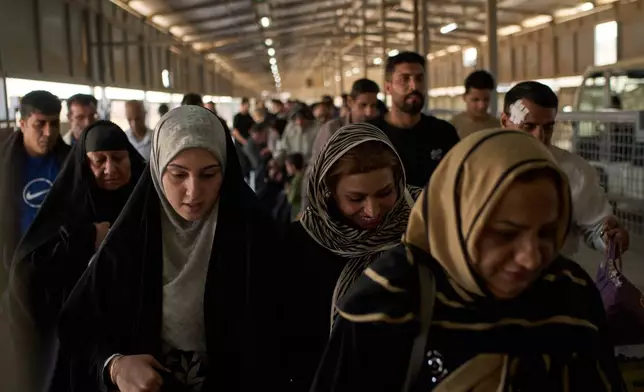 People who arrived from Iran cross the Shalamcheh border crossing between Iran and Iraq, near Basra, Iraq, Sunday, March 29, 2026. (AP Photo/Leo Correa)