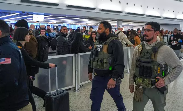 Federal immigration agents walk through Terminal 5 at John F. Kennedy International Airport (JFK) in the Queens borough of New York, Monday, March 23, 2026. (AP Photo/Ryan Murphy)