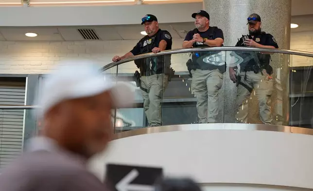Federal immigration agents are seen at the Hartsfield-Jackson Atlanta International Airport, Monday, March 23, 2026, in Atlanta. (AP Photo/Mike Stewart)