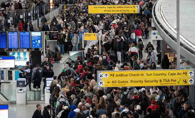 People wait in a TSA line at the John F. Kennedy International Airport, Sunday, March 22, 2026, in New York. (AP Photo/Yuki Iwamura)