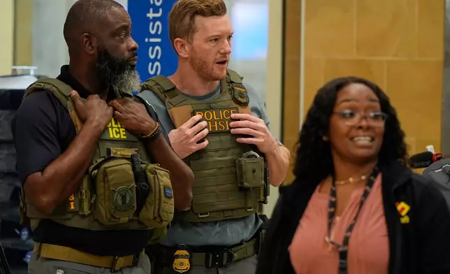 Federal immigration agents are seen at the Hartsfield-Jackson Atlanta International Airport, Monday, March 23, 2026, in Atlanta. (AP Photo/Mike Stewart)