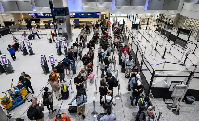 Airline passengers make their way through the security lines, next to a closed screening area, in Terminal C at George Bush Intercontinental Airport, Sunday, March 29, 2026, in Houston. (Brett Coomer/Houston Chronicle via AP)
