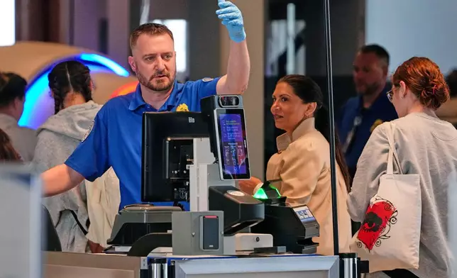 A TSA agent checks passengers at the security checkpoint in Pittsburgh International Airport Monday, March 30, 2026. (AP Photo/Gene J. Puskar)