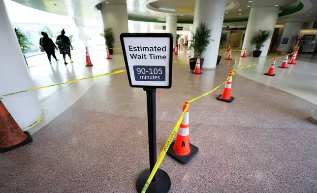An estimated wait time sign stands in a TSA security line at George Bush Intercontinental Airport on Monday, March 30, 2026, in Houston. (AP Photo/Ashley Landis)