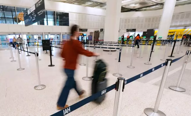 A traveler walks through TSA security lines at George Bush Intercontinental Airport on Monday, March 30, 2026, in Houston. (AP Photo/Ashley Landis)
