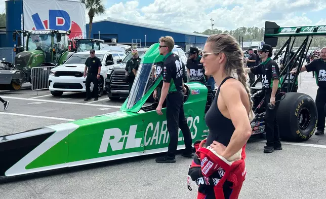 NHRA driver Leah Pruett watches as her husband, fellow racer Tony Stewart, gets pushed onto the starting line at the Gatornationals, Saturday, March 7, 2026, in Gainesville, Fla. (AP Photo/Mark Long)