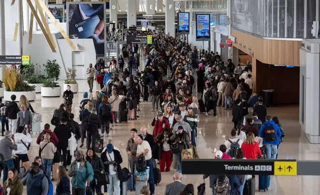 Travelers wait in a TSA line, Wednesday, March 25, 2026, at LaGuardia Airport in New York. (AP Photo/Yuki Iwamura)