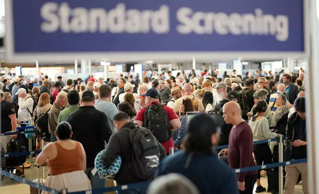 Passengers wait in a security checkpoint line at George Bush Intercontinental Airport, Wednesday, March 25, 2026, in Houston. (AP Photo/David J. Phillip)