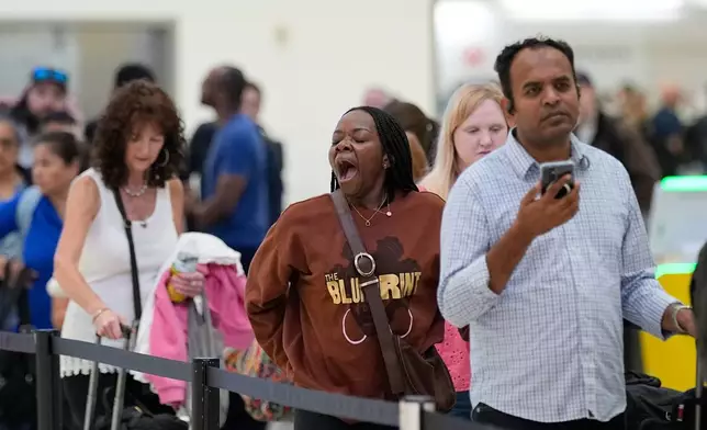 Passengers wait in a security checkpoint line at George Bush Intercontinental Airport, Wednesday, March 25, 2026, in Houston. (AP Photo/David J. Phillip)