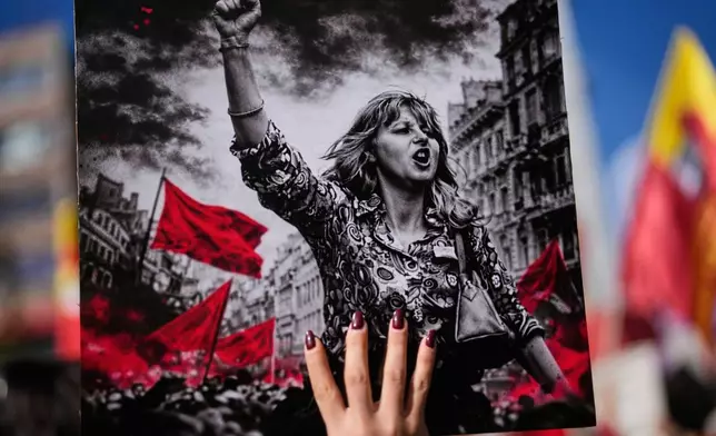 A woman holds up a placard during a protest marking the International Women's Day, in Istanbul, Turkey, Sunday, March 8, 2026. (AP Photo/Khalil Hamra)