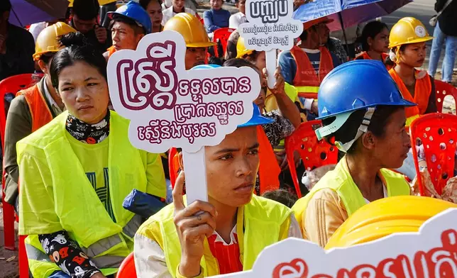 A local worker, front left, holds a banner reading "Women receive equal pay to men" during International Women's Day celebrations in Phnom Penh, Phnom Penh Cambodia, Sunday, March 8, 2026. (AP Photo/Heng Sinith)