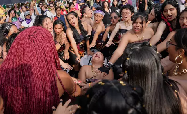 Women perform a good luck ceremony before a march marking International Women's Day, in Lima, Peru, Saturday, March 7, 2026. (AP Photo/Martin Mejia)