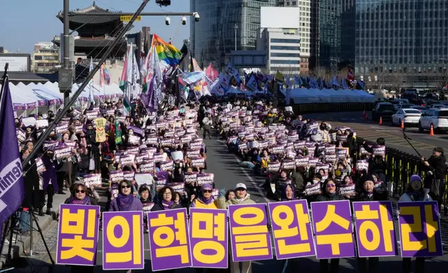 South Korean activists gather a day ahead of International Women's Day in Seoul, South Korea, Saturday, March 7, 2026. The banners read "Complete the revolution of light." (AP Photo/Ahn Young-joon)
