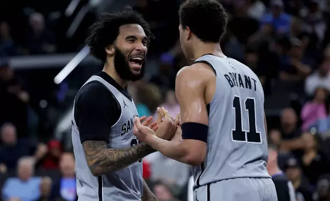 San Antonio Spurs forward Julian Champagnie, left, reacts with forward Carter Bryant (11) during the first half of an NBA basketball game against the Los Angeles Clippers, Monday, March 16, 2026, in Inglewood, Calif. (AP Photo/Ryan Sun)