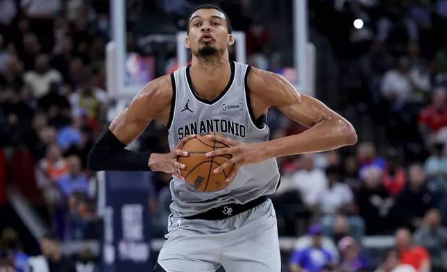 San Antonio Spurs forward Victor Wembanyama prepares to pass the ball during the first half of an NBA basketball game against the Los Angeles Clippers, Monday, March 16, 2026, in Inglewood, Calif. (AP Photo/Ryan Sun)