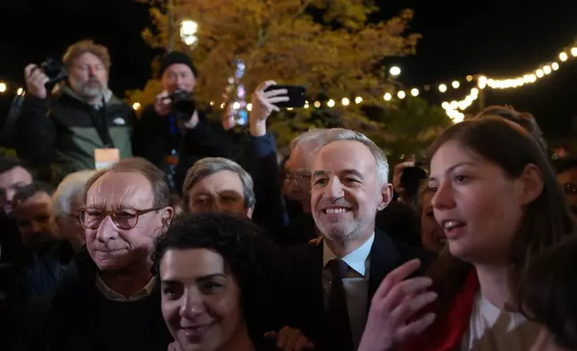 French socialist candidate for Paris mayoral election, Emmanuel Gregoire, center right, and former Paris' mayor Bertrand Delanoe, left, celebrate after Gregoire won the second round of France's municipal elections in Paris, France, Sunday, March 22, 2026. (AP Photo/Thibault Camus)