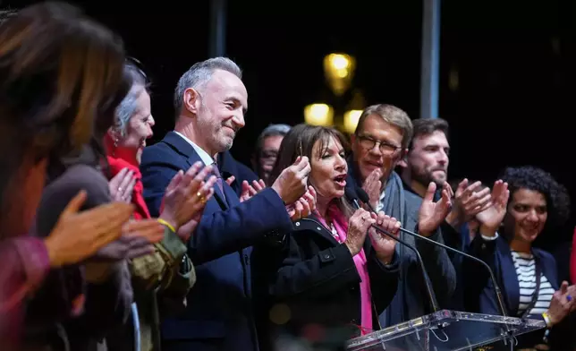 French socialist candidate for Paris mayoral election Emmanuel Gregoire, center left, and, Anne Hidalgo, center right, give a speech after Gregoire won the second round of France's municipal elections in Paris, Sunday, March 22, 2026. (AP Photo/Thibault Camus)