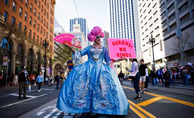 Drag queen Dirty Carol joins the third "No Kings" day event at Embarcadero Plaza before marching to Civic Center Plaza in San Francisco on Saturday, March 28, 2026. (Yalonda M. James/San Francisco Chronicle via AP)