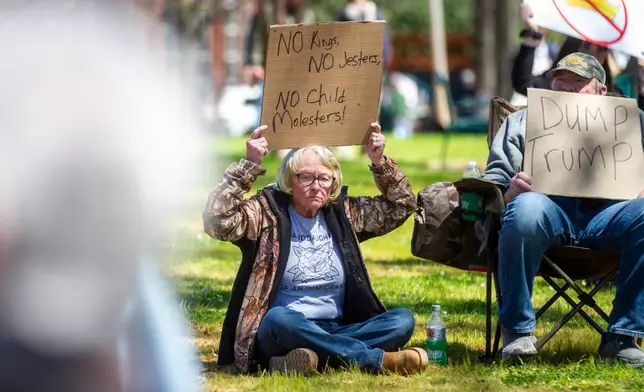 Demonstrators hold signs during the "No Kings" rally at Wilson Park in Florence, Ala, on Saturday, March 28, 2026. (Dan Busey/The TimesDaily via AP)