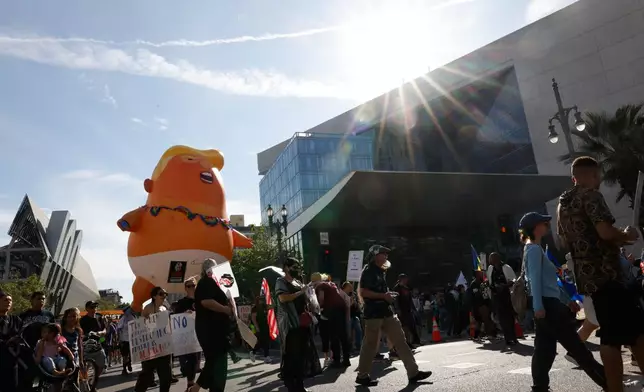 Demonstrators march in downtown Los Angeles during a "No Kings" protest Saturday, March 28, 2026. (AP Photo/Jill Connelly)