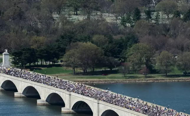 Demonstrators march across Memorial Bridge during the No Kings protest in Washington, Saturday, March 28, 2026. (AP Photo/Allison Robbert)