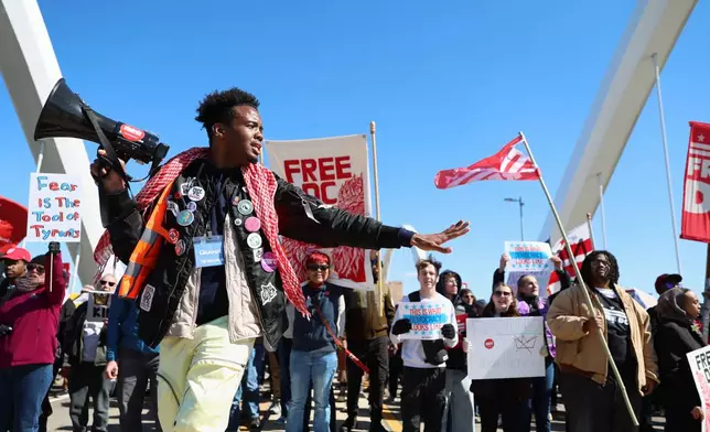 Demonstrators march over the Frederick Douglass Bridge during the No Kings protest in Washington, Saturday, March 28, 2026. (AP Photo/Tom Brenner)