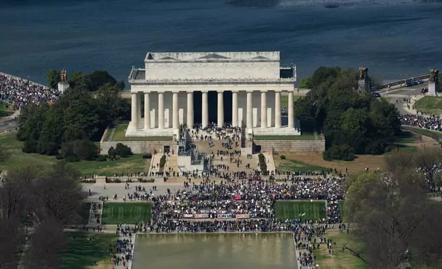 Demonstrators march across Memorial Bridge and around the Lincoln Memorial during the No Kings protest in Washington, Saturday, March 28, 2026. (AP Photo/Allison Robbert)