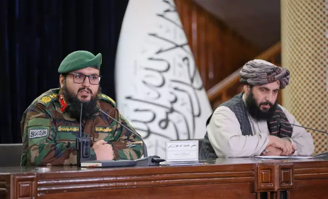 Enayatullah Khowarazmi , left, spokesman of the Defence Ministry, and Hamdullah Fitrat ,deputy spokesman for the Islamic Emirate of Afghanistan speak during a press conference in Kabul, Afghanistan, Tuesday, March 3, 2026.(AP Photo/Siddiqullah Alizai)
