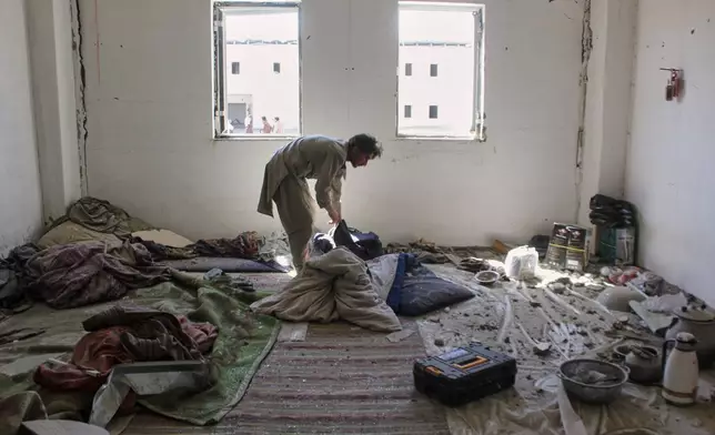 A man inspects a building damaged after a Pakistani strike in on a refugee camp in Takhta Pul district, Kandahar province, Afghanistan, Saturday, Feb. 28, 2026. (AP Photo/Sibghatullah)