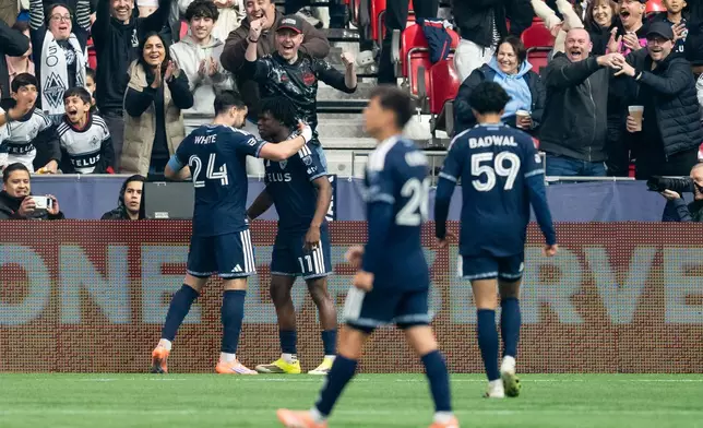 Vancouver Whitecaps' Brian White (24) celebrates his goal against Minnesota United with Emmanuel Sabbi during the first half of an MLS soccer match in Vancouver, British Columbia, Sunday, March 15, 2026. (Ethan Cairns/The Canadian Press via AP)