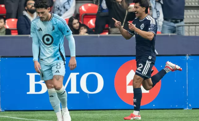 Vancouver Whitecaps' Mathias Laborda, right, celebrates his goal as Minnesota United's Tomas Chancalay walks away during the first half of an MLS soccer match in Vancouver, British Columbia, Sunday, March 15, 2026. (Ethan Cairns/The Canadian Press via AP)