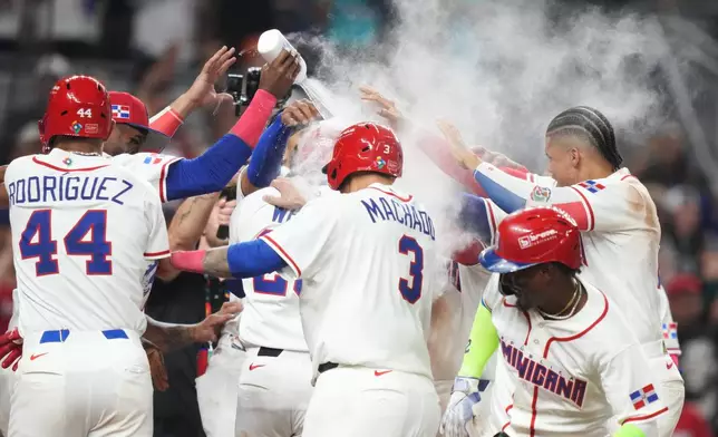 Dominican Republic's Austin Wells (28) gets doused as he celebrates with teammates after hitting a three-run home run to end the game early in the seventh inning of a World Baseball Classic quarterfinal game against South Korea, Friday, March 13, 2026, in Miami. (AP Photo/Lynne Sladky)