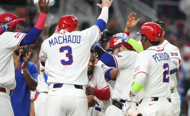 Dominican Republic's Austin Wells, second right, is congratulated by teammates after hitting a three-run home run to end the game early in the seventh inning of a World Baseball Classic quarterfinal game against South Korea, Friday, March 13, 2026, in Miami. (AP Photo/Lynne Sladky)