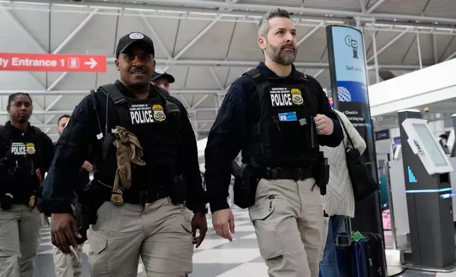 Federal immigration officers walk though the terminal 1 at O'Hare International Airport in Chicago, Tuesday, March 24, 2026. (AP Photo/Nam Y. Huh)