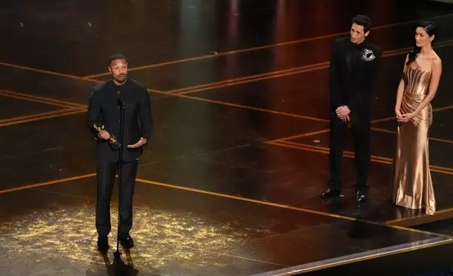 Michael B. Jordan accepts the award for actor in a leading role for "Sinners" during the Oscars on Sunday, March 15, 2026, at the Dolby Theatre in Los Angeles. Adrien Brody looks on from right.(AP Photo/Chris Pizzello)
